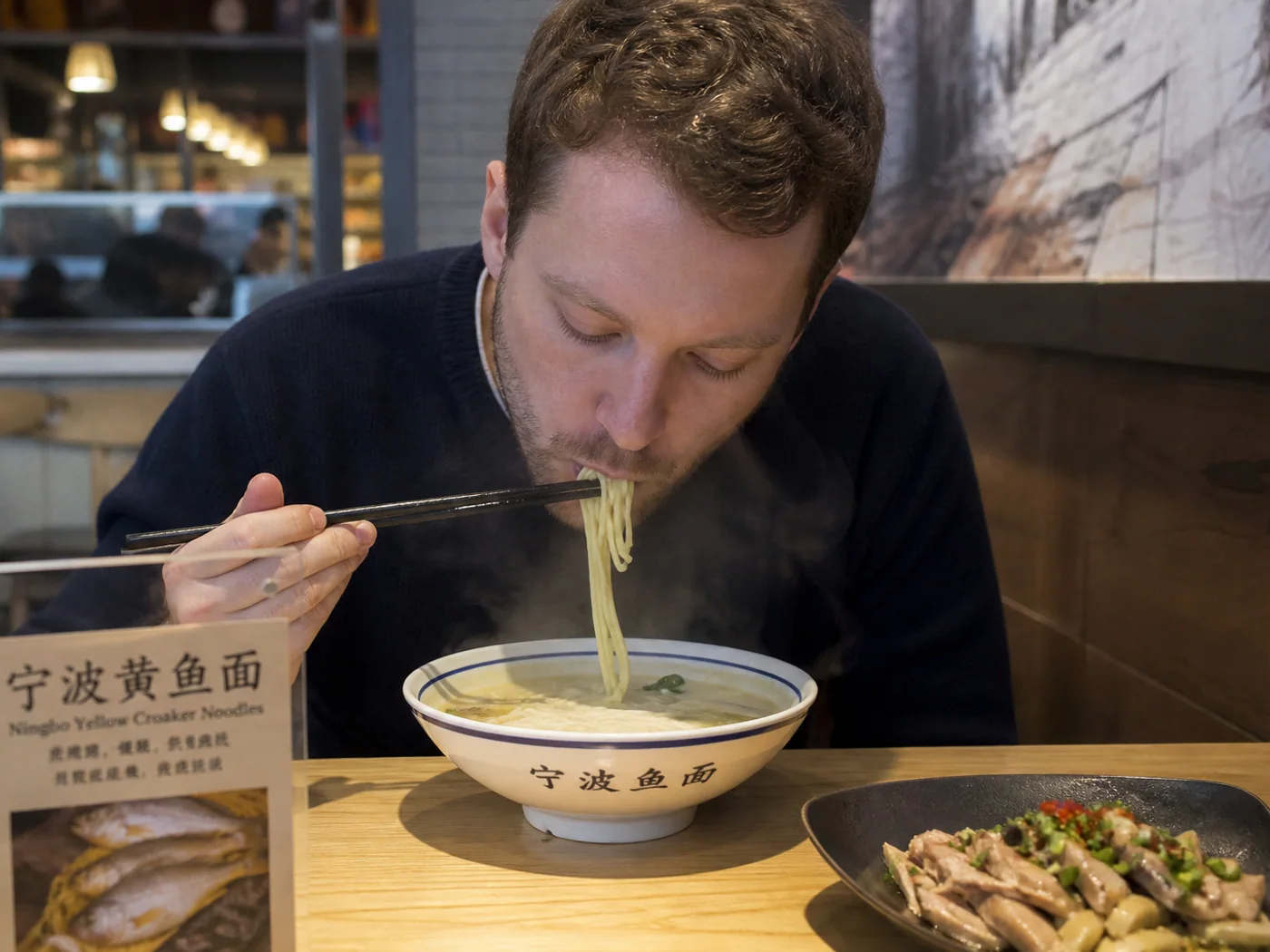 Traveler eating fish noodles