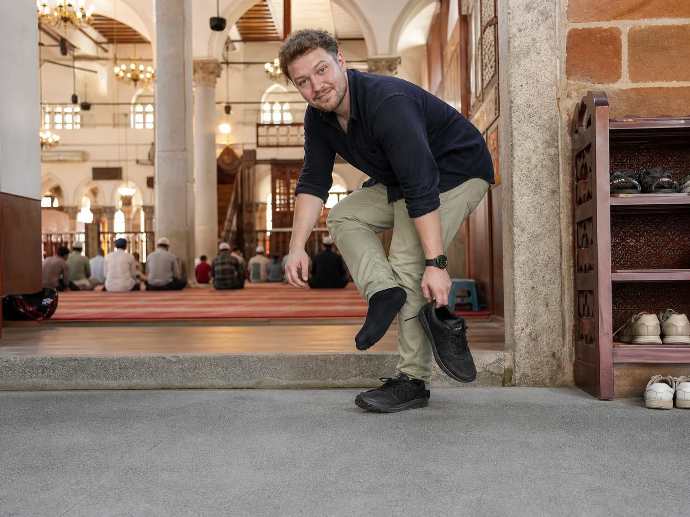 Traveler removing shoes at mosque